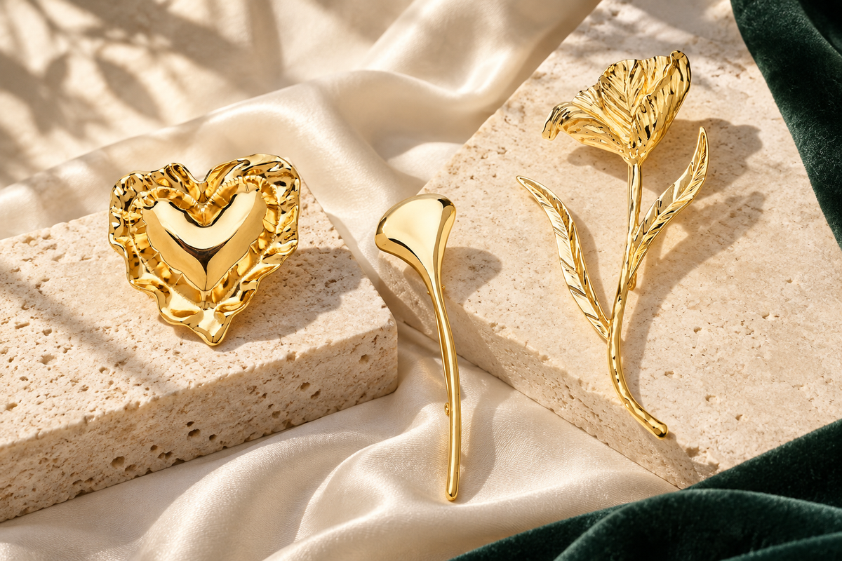 Gold-tone heart, ginkgo leaf and tulip brooches on ivory stone and silk