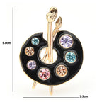 Broche palette d'artiste en émail avec peintures ornées de bijoux
