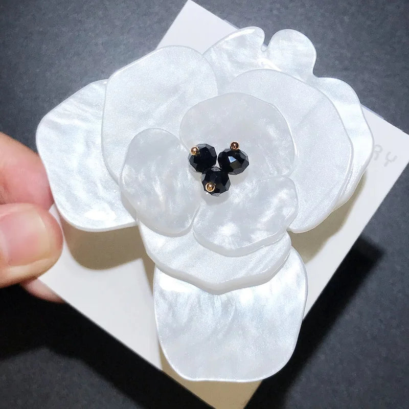 Broche fleur en acrylique superposé avec centre en perle noire