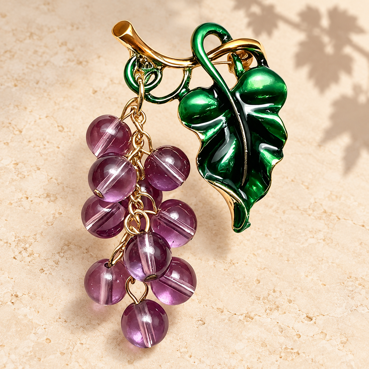 Dangling Grape Cluster with Leaf Brooch — styled background