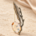 Jeweled Feather with Faceted Drop Brooch — styled background