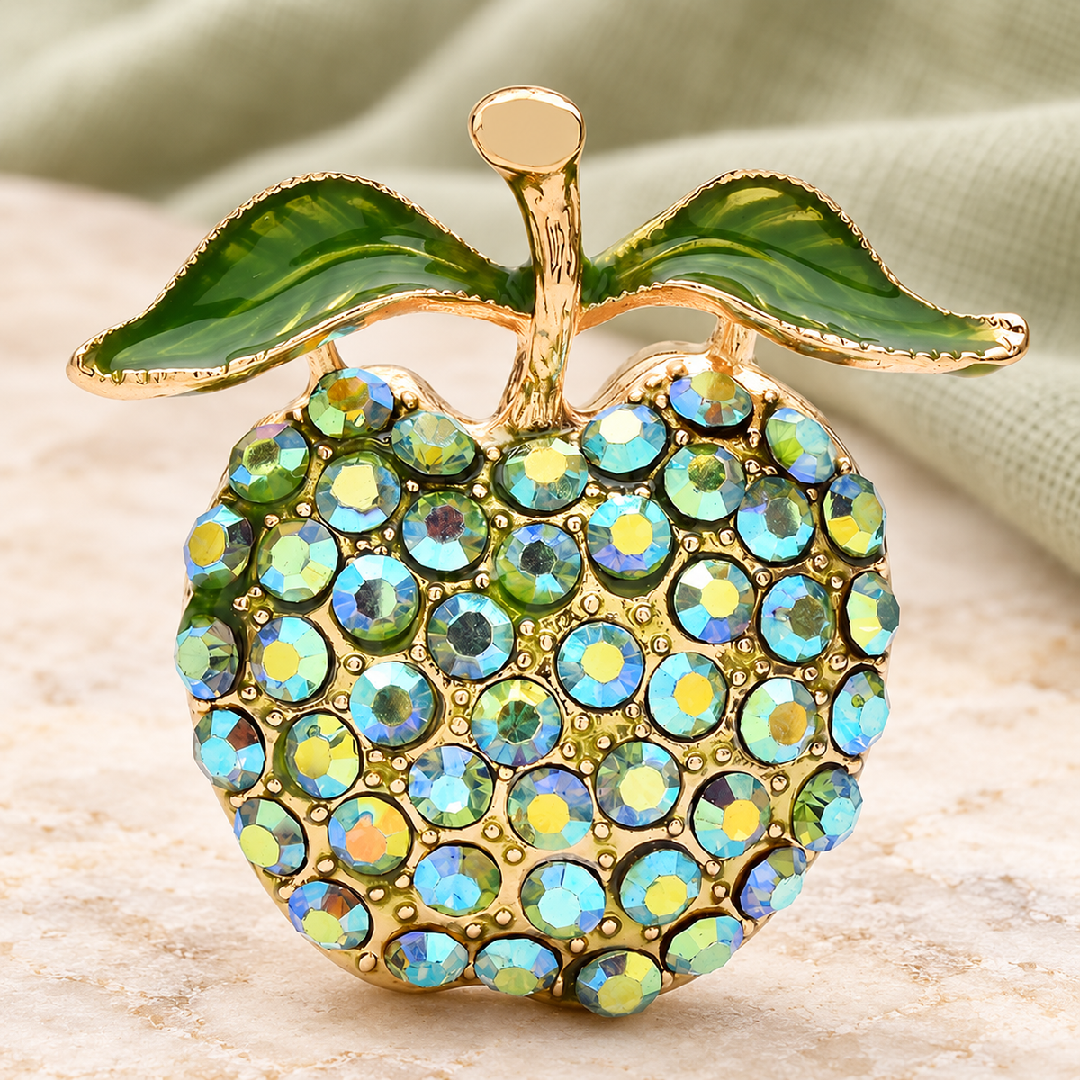 Green Rhinestone Apple Brooch — styled background