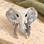 Enamel Elephant Head with Jeweled Tusks Brooch — styled background