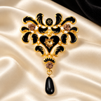 Black Enamel Floral Scroll with Teardrop Brooch — styled background