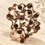 Openwork Rhinestone Flower with Teardrop Brooch — styled background