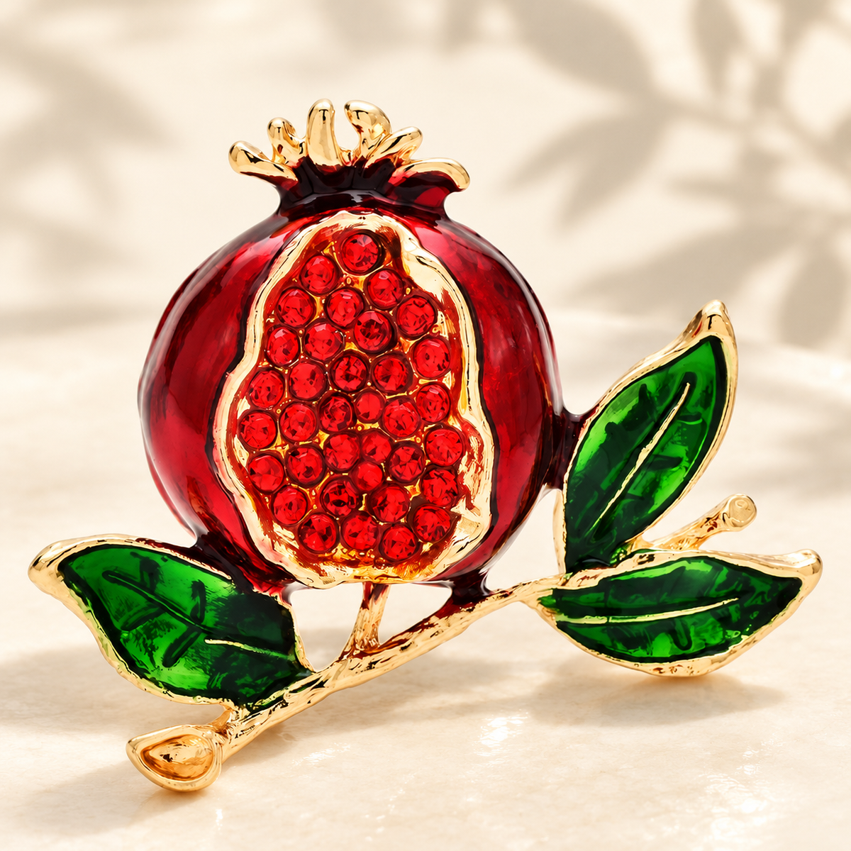 Jeweled Pomegranate on Leafy Branch Brooch — styled background