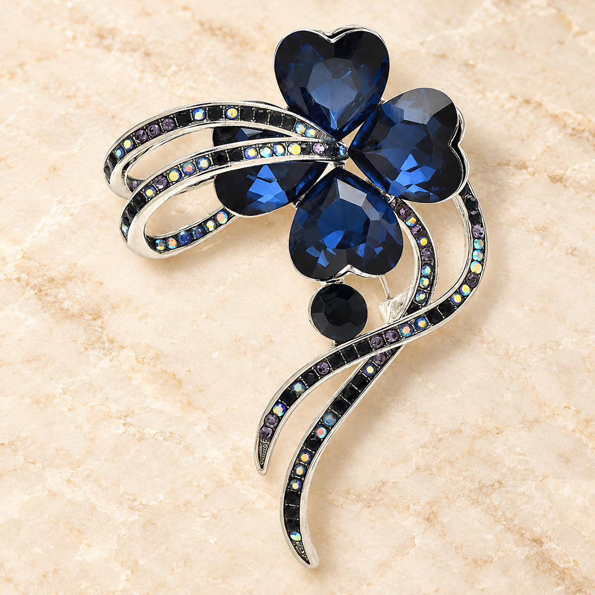 Faceted Heart-Petal Flower with Ribbon Trails Brooch — styled background