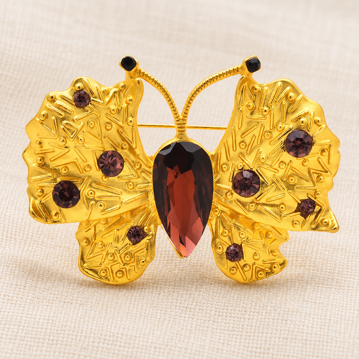 Textured Golden Butterfly with Brown Faceted Accents Brooch — styled background