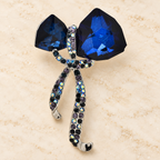 Faceted Bow with Rhinestone Ribbon Tails Brooch — styled background