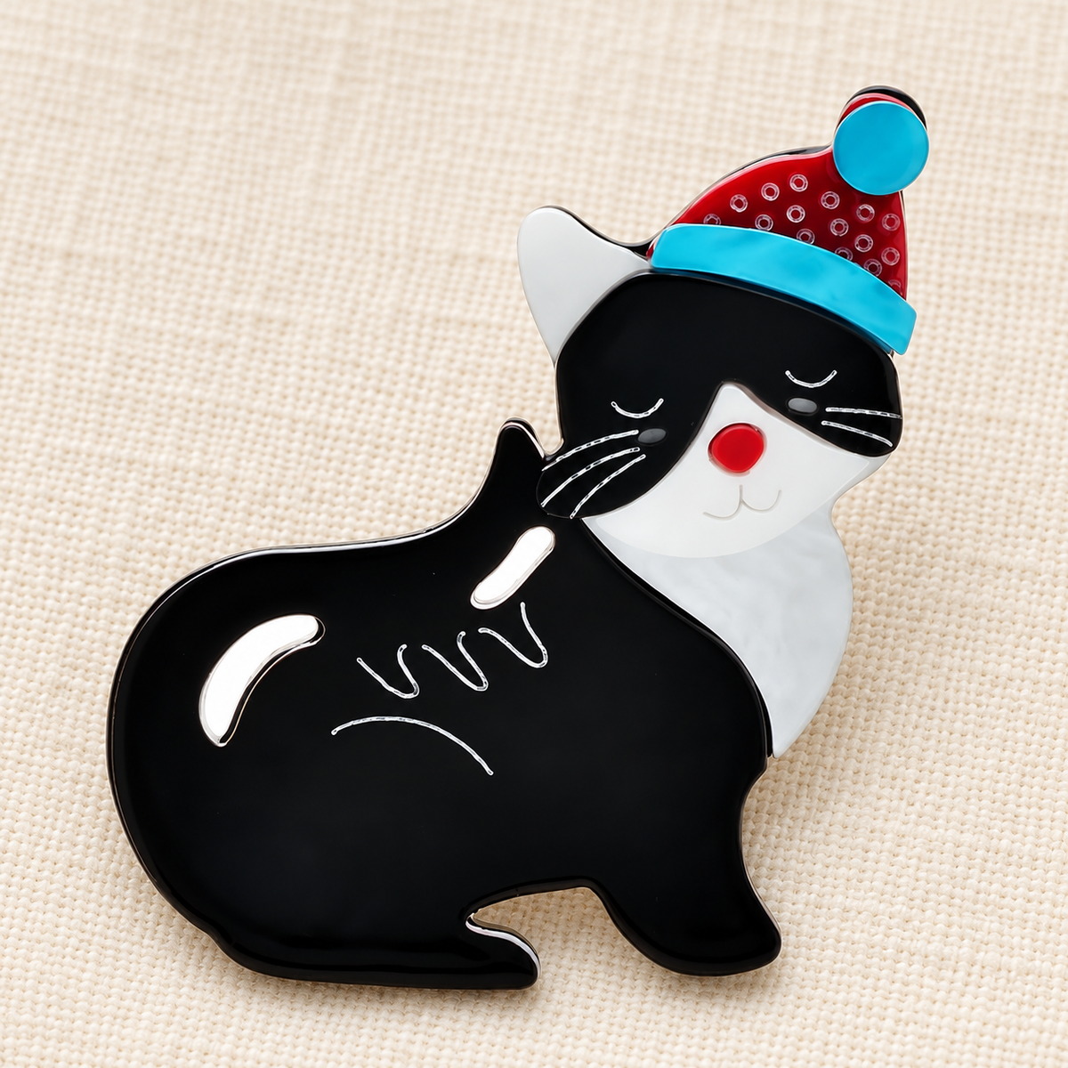 Black Acrylic Cat in Festive Hat Brooch — styled background