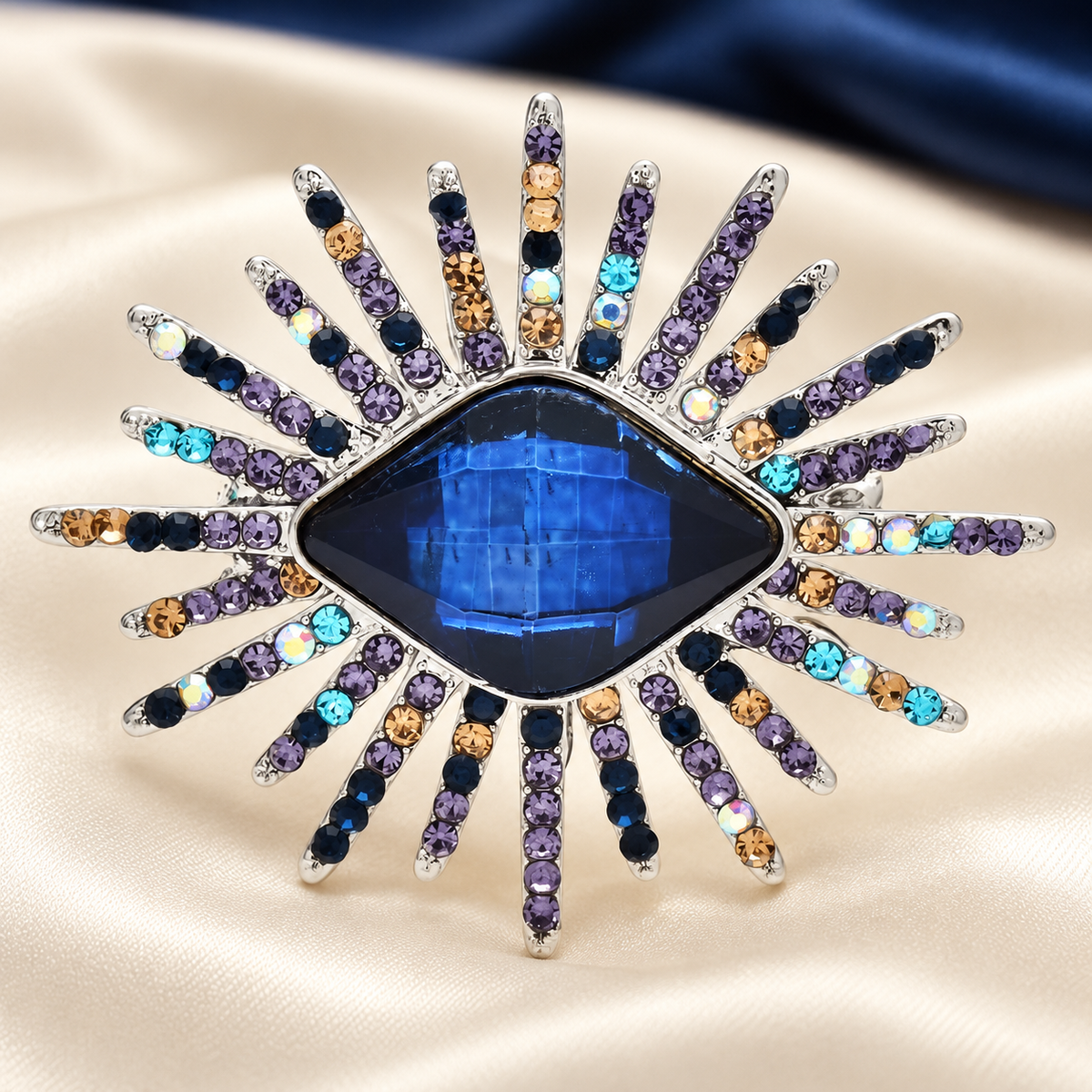 Faceted Eye with Radiating Rhinestone Rays Brooch — styled background