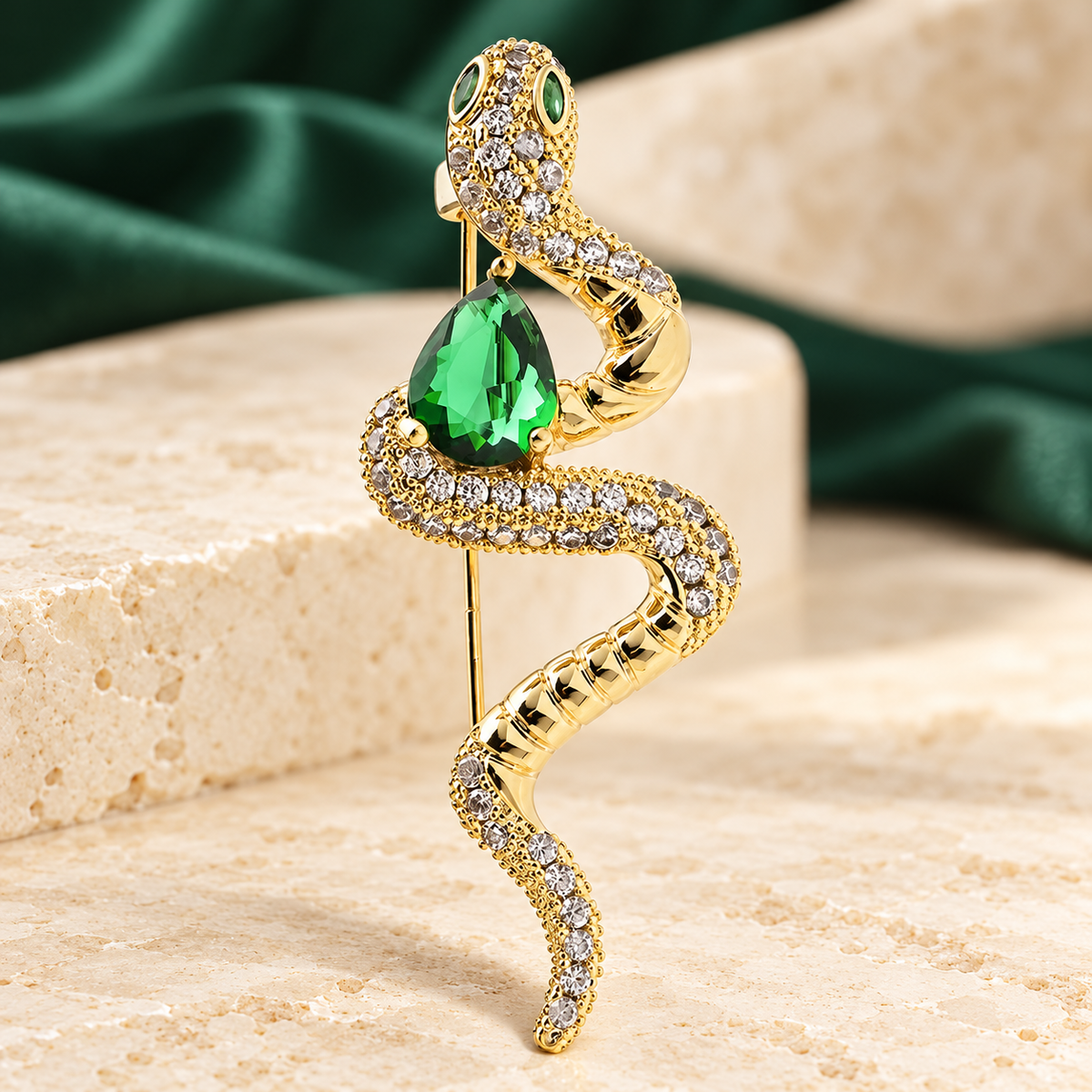 Coiled Snake with Green Teardrop Brooch — styled background