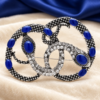 Intertwined Rhinestone Snakes Brooch — styled background
