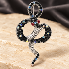Looped Rhinestone Snake Brooch — styled background