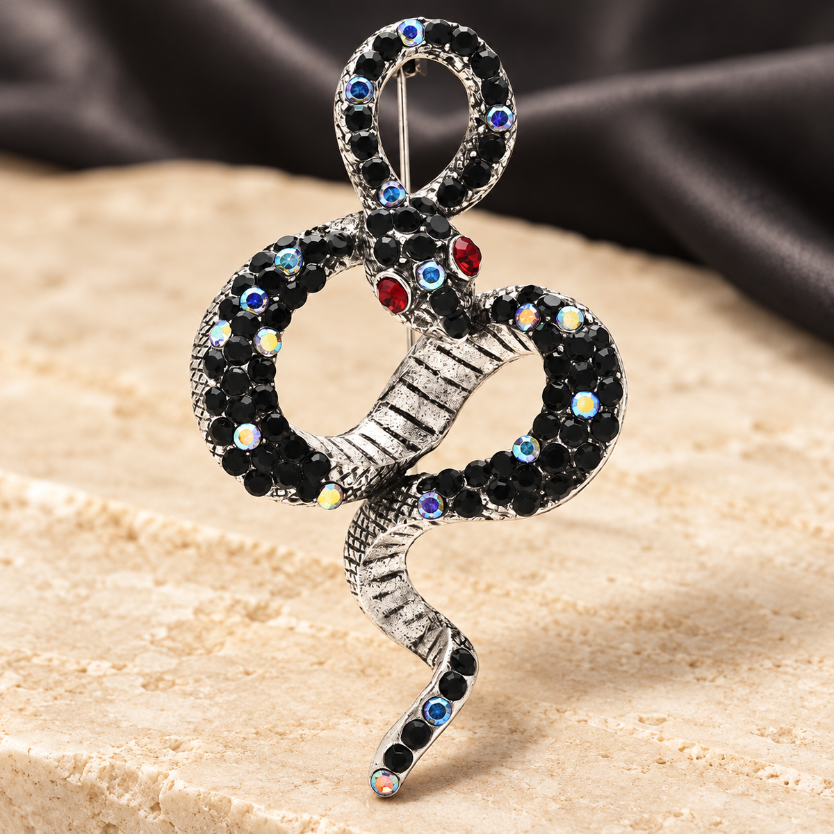 Looped Rhinestone Snake Brooch — styled background