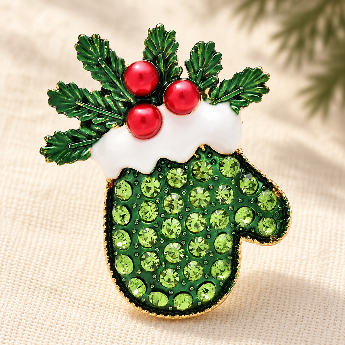 Holly and Rhinestone Christmas Mitten Brooch — styled background