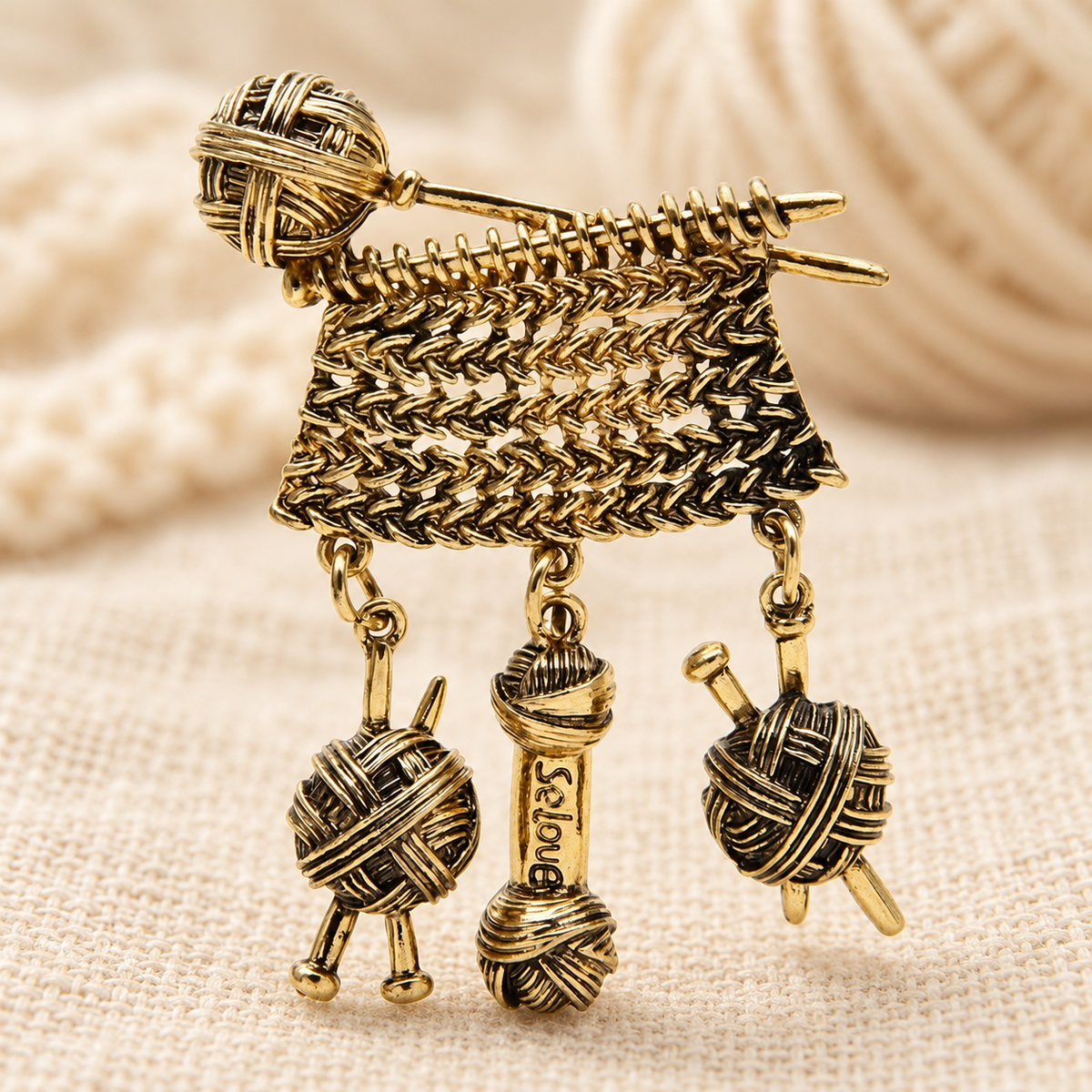 Knitting Needles with Dangling Yarn Balls Brooch — styled background