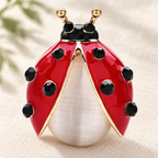 Red Enamel Ladybug with Ivory Accent Brooch — styled background