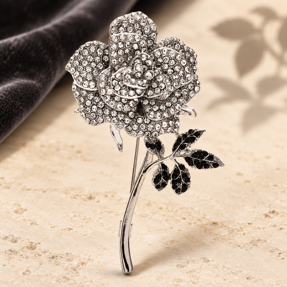 White Rhinestone Rose with Black Leaves Brooch — styled background