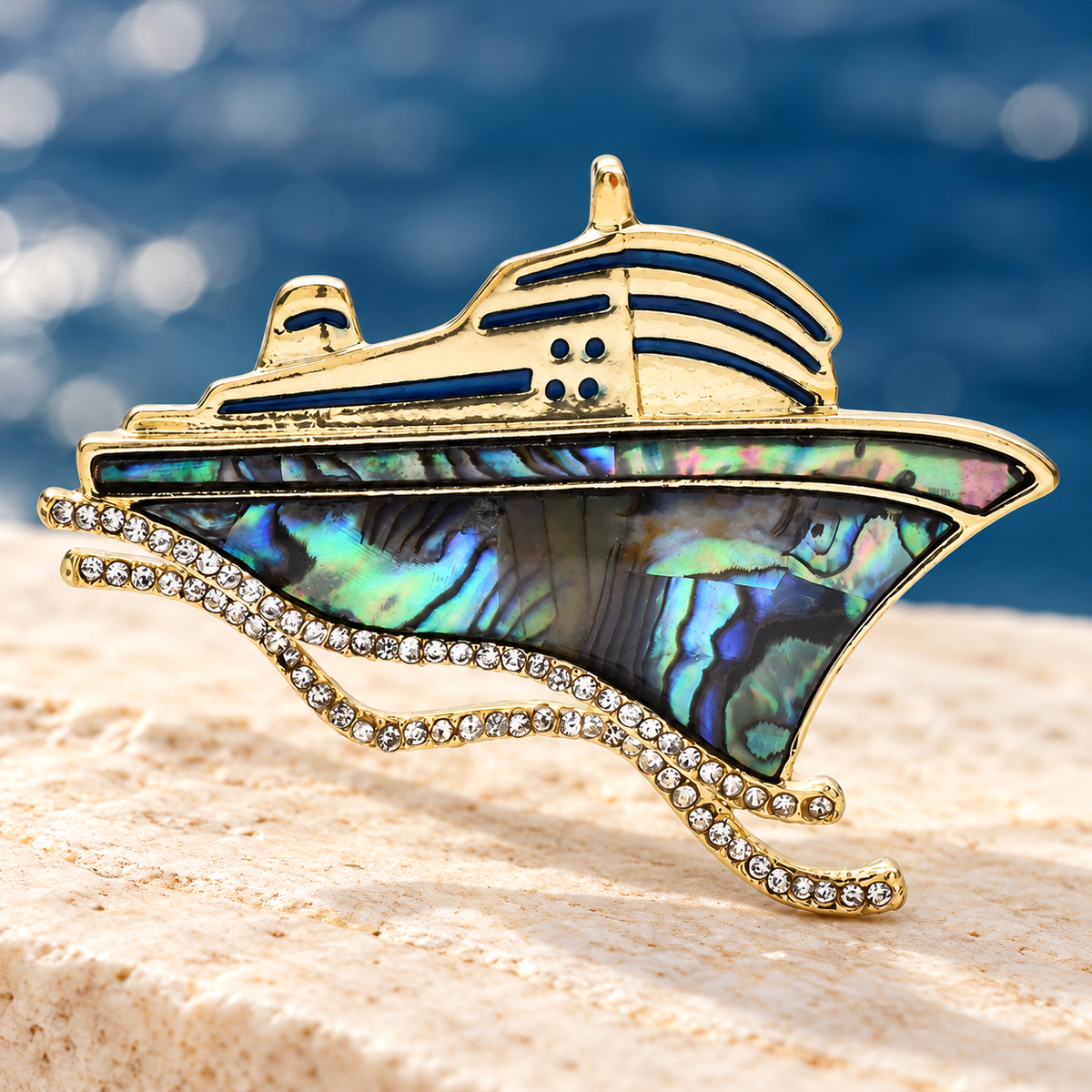 Abalone-Look Cruise Ship with Rhinestone Waves Brooch — styled background