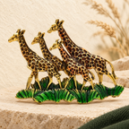 Enamel Giraffe Family in Grass Brooch — styled background