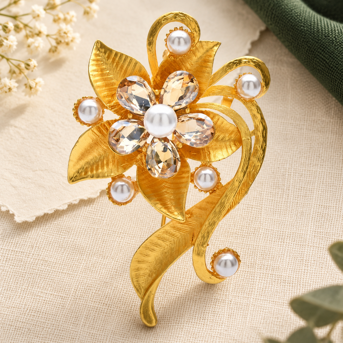Golden Leaf Scroll Flower with Rhinestones Brooch — styled background