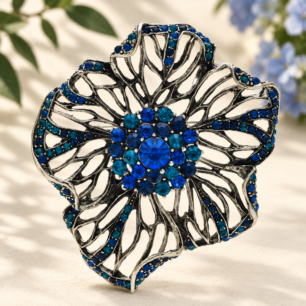 Large Openwork Flower with Rhinestone Center Brooch — styled background