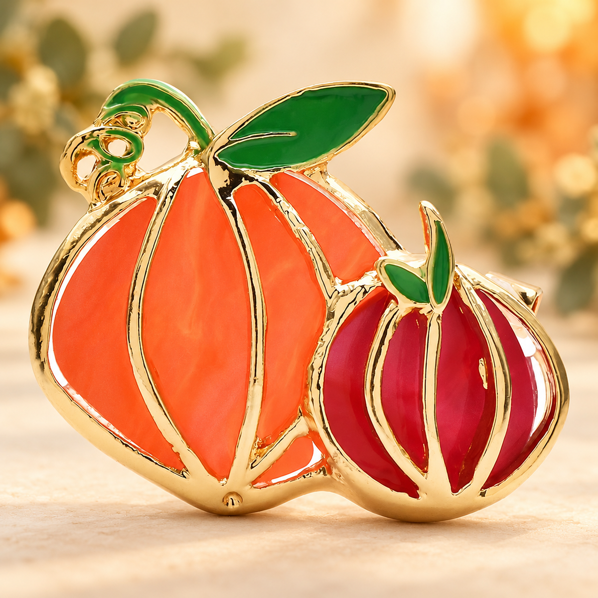 Enamel Pumpkin Pair with Green Leaves Brooch — styled background