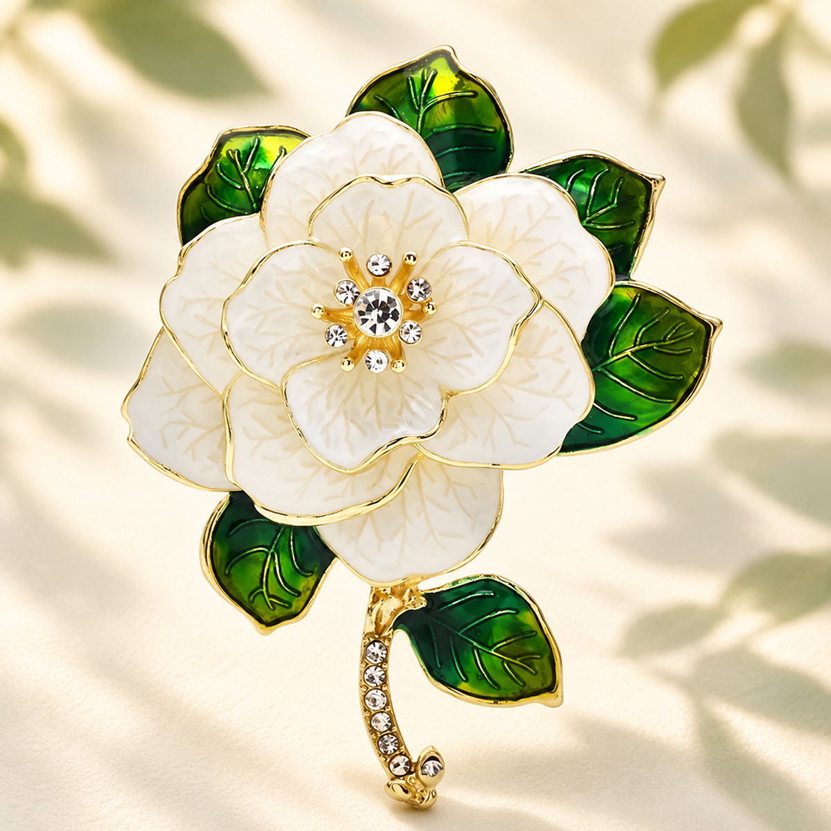 White Enamel Camellia with Green Leaves Brooch — styled background