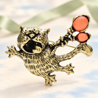 Vintage-Style Flying Cat with Balloons Brooch — styled background