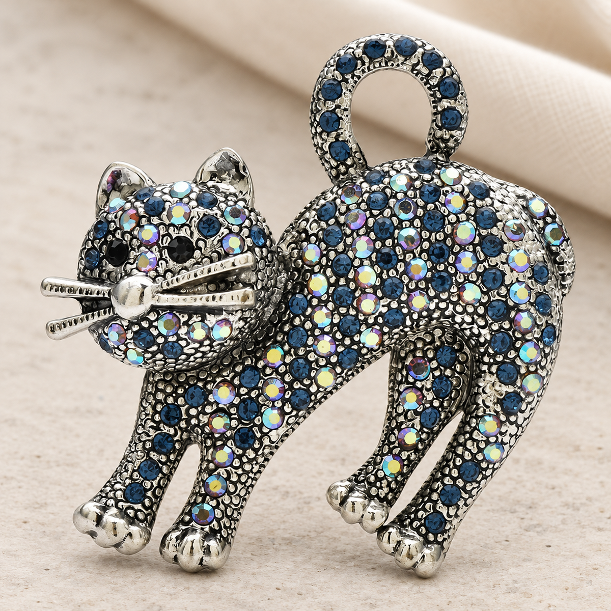 Arched-Back Rhinestone Cat Brooch — styled background