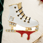 Lace-Up Enamel Ice Skate Brooch on an elegant ivory, deep green and gold background