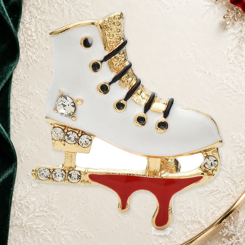 Lace-Up Enamel Ice Skate Brooch on an elegant ivory, deep green and gold background