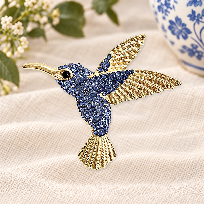Sparkling Hummingbird with Textured Wings Brooch on a motif themed ivory backdrop